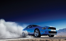 Синий Ford Mustang поднимает пыль